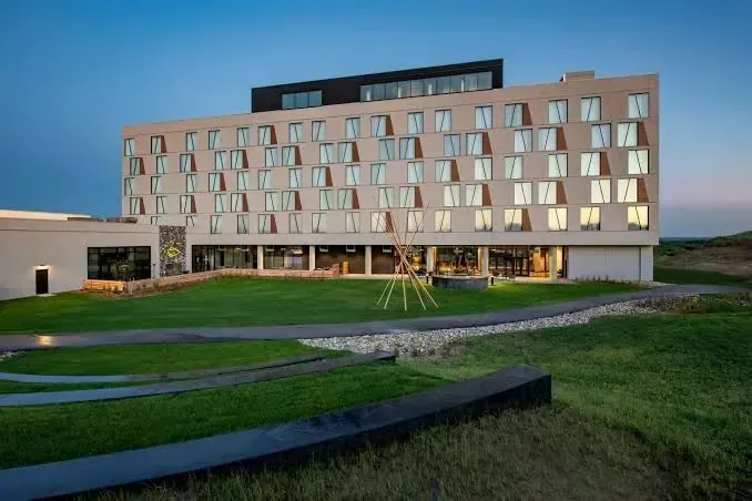 Low-rise resort building on open prairie at dusk, Dakota Dunes Resort, Whitecap